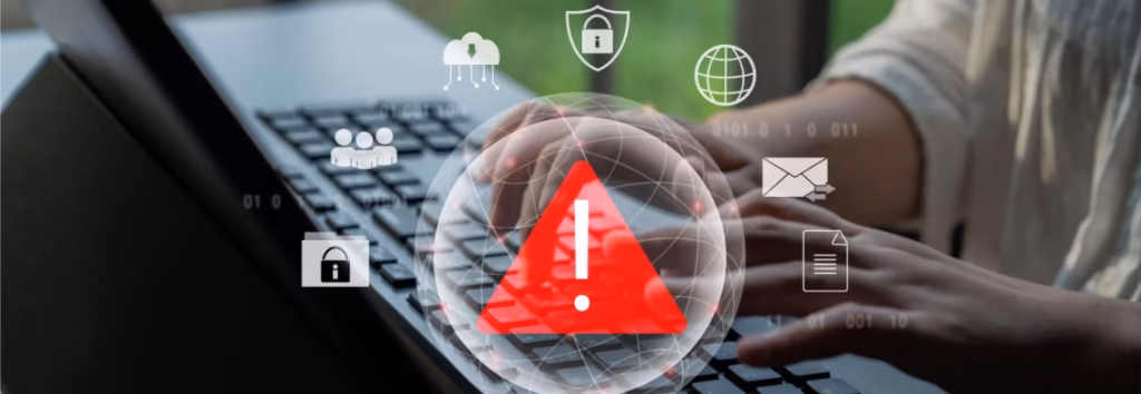 Close up of hands using a laptop with a red warning overlaying and digital symbols such as email and web browser. Data Breach v Data Misuse Featured Image